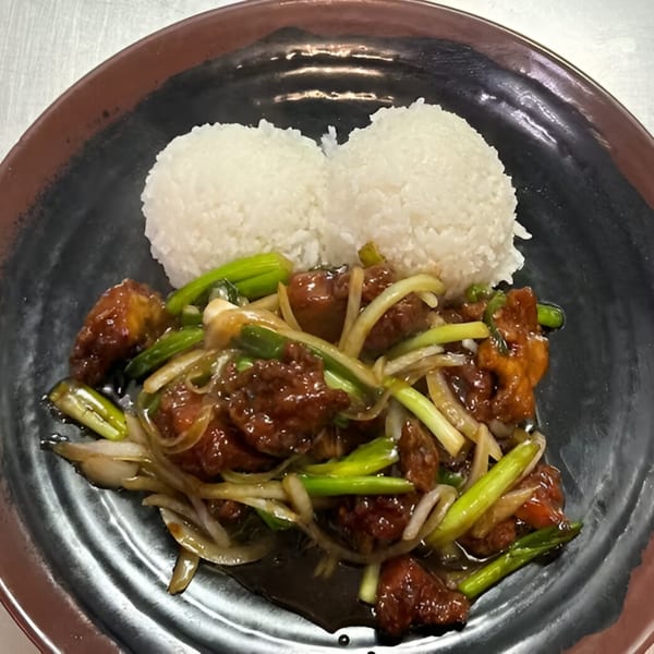 Koto Teriyaki & Sushi's teriyaki chicken with green onions, white onions, and two scoops of white rice.